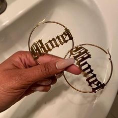 a person is holding onto some type of metal nameplates in front of a sink