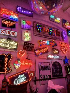 a room with neon signs and lights on the wall, including a disco ball hanging from the ceiling