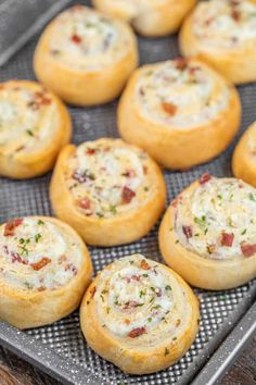 several mini pizzas are on a baking sheet