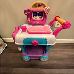 a pink and blue toy kitchen playset on the floor