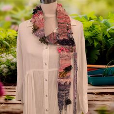 a woman's white shirt and pink scarf on a mannequin headdress