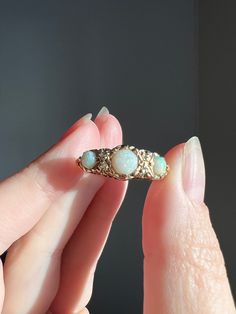 ABOUT: Nice sized three opal ring with rose cut diamond spacers.  The underside / gallery of the ring is ornately pierced holding the ring face up and adding a nice height.  Substantial to wear alone but also an excellent stacker. Antique box is not included.  Please note the measurements as I have small fingers and it can be difficult to determine scale from pictures. HALLMARKS: UK Hallmarks for 18k gold, Birmingham, 1905. MEASUREMENTS: Size 7 1/4.  Ring face is 7.7mm north south and about 5.3mm tall off the finger. It weighs a sturdy 3.7grams.  IMPORTANT CONDITION NOTES: Some small nicks to the opals but overall nice sheen and polish and no cracks.  The gold has some build up and a matte finish yellow gold in the recesses with a shinier rose gold on the raised areas. Typical antique rose Victorian 14k Gold Opal Ring For Anniversary, Victorian Style Opal Round Rings, Victorian Multi-stone Opal Ring As Gift, Victorian Multi-stone Opal Ring For Gift, Victorian Multi-stone Opal Ring, Victorian 14k Gold Opal Ring Gift, Opal Ring With Rose Cut Diamonds For Anniversary, Heirloom Opal Ring With Rose Cut Diamonds For Promise, Anniversary Opal Ring With Rose Cut Diamonds