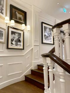 a staircase with pictures on the wall and wooden floors