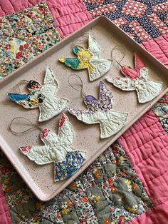 a tray that has some cookies on it and is sitting on a quilted surface