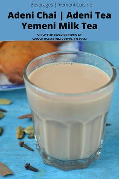 a glass filled with milk sitting on top of a blue table next to other food