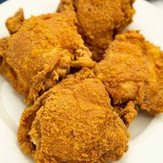 fried chicken on a white plate sitting on a marble table