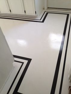 a white and black striped floor in a kitchen with cupboards on the far side