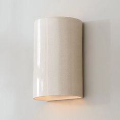 a white wall light mounted on the side of a wall