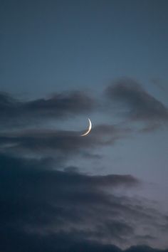 the moon is seen through some dark clouds