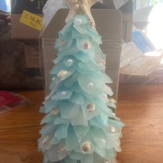 a plastic christmas tree with seashells and starfish on it's top