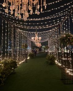 an outdoor wedding venue decorated with lights and chandeliers