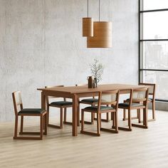 a wooden table with four chairs and a vase on it