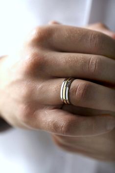 a woman's hand with two gold rings on her left and one white ring on her right