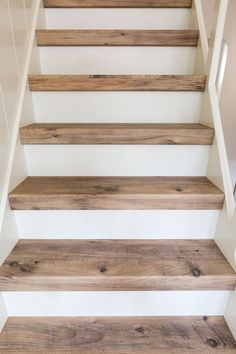 wooden stairs with white painted walls and wood flooring