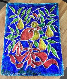 this is an image of a handmade glass tile with fruit and leaves on it