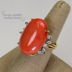 This rare Japanese Momo Coral Ring is set in 18k solid gold. 6 round diamonds and 4 marquise diamonds surround the coral.Ring Size: 6Total Weight: 11.7 gramsPrecious Metal: 18k solid goldPrecious stones:-Coral Center Stone: 25.5mm x 17.8mm-White Round and Marquise Diamonds Elegant Oval Coral Rings, Elegant Coral Oval Rings, Formal Coral Ring, Elegant Coral Ring Jewelry, Elegant Coral Rings For Anniversary, Elegant Coral Jewelry For Anniversary, Coral Elegant Wedding Rings, Elegant Coral Wedding Rings, Luxury Coral Jewelry For Formal Occasions