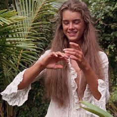 a woman with long hair holding something in her hands