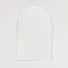 a white wall with an arch shaped mirror