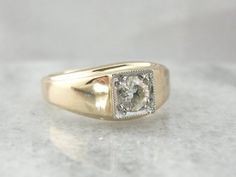 Originally intended for a man, this is suitable for a lady as well! 14k yellow gold with a polished profile, this ring dates to the late 1940's to early 1950's. Likely originally set with a synthetic sapphire or ruby, we've replaced the center stone with a bright diamond. Suitable for a man or a lady, as a wedding band, an anniversary gift or an everyday ring. Metal: 14K Yellow  GoldCenter Stone: Square Diamond - .60 carat, SI1 in Clarity, K in ColorSize of Ring: 10, but can be sized to fit almo 1950s Mens, Everyday Ring, Dainty Studs, Everyday Rings, Square Diamond, Ring Metal, Men's Rings, A Lady, Ring Ring