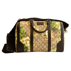 A Gucci duffle convertible handbag/cross body bag with brown green print blooms coated canvas and black leather trim & silver tone hardware. The interior is lined with dark brown synthetic fabric, and next to the major compartment it features two side pockets of which one has a zipper. The shoulder strap is made of canvas and it is detachable and in the length adjustble (max 130 cm). The condition is good with minor scratches on the leather trim and the hardware. Boston Bag, Green Print, Synthetic Fabric, Cross Body Bag, Leather Trim, Fashion Handbags, Body Bag, Leather Trims, Purses Crossbody