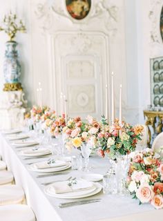 a long table is set with flowers and candles for an elegant wedding reception at the palace