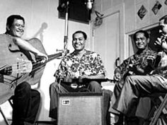 three men are sitting in chairs with guitars