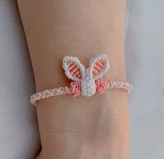 a woman's arm with a pink and white bracelet that has a bunny head on it