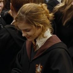 a woman in a harry potter costume looking at her cell phone