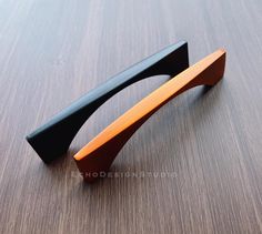 an orange and black door handle on a wooden surface