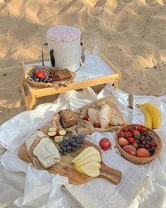 two trays filled with food sitting on top of a white blanket next to an open book