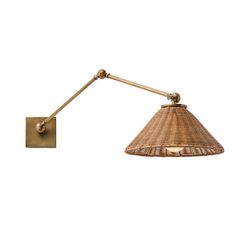 a wall light with a rattan shade on the side and a gold metal arm