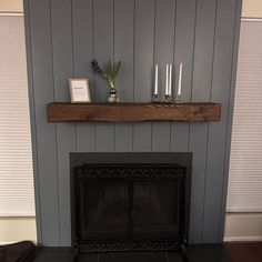 a living room with a fireplace and some candles on top of the mantels