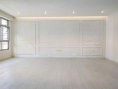 an empty room with white walls and wood floors