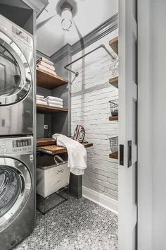 a washer and dryer in a small room with shelves on either side of the door