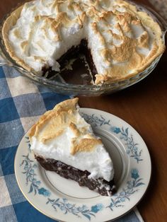 a piece of pie sitting on top of a white plate next to a blue and white checkered table cloth