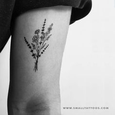 a black and white photo of a flower tattoo on the left side of the leg