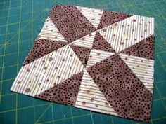 a close up of a piece of fabric on a cutting board with a green background