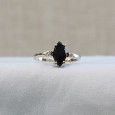 This ring is a unique combination of a marquise shaped black onyx and yellow gold. Two tiny accent diamonds add .01 carats of sparkle. Prong set stones Marquise Black Jewelry For Anniversary, Black Marquise Jewelry For Anniversary, Black Marquise Cut Promise Ring, Black Marquise Ring As Gift, Black Marquise Cut Jewelry For Anniversary, Black Marquise Diamond Rings, Black Marquise Cut Jewelry For Gift, Black Marquise Diamond Jewelry, Black Marquise Ring Gift