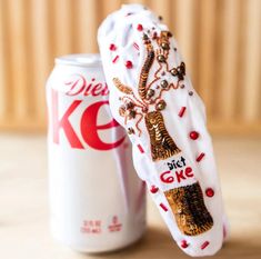 a coca - cola can is next to a pair of shoes that are decorated with sequins