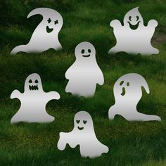 six ghost cut outs sitting in the grass