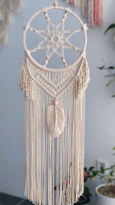 a white dream catcher hanging on the wall