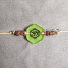 a green beaded bracelet with an omen symbol on it