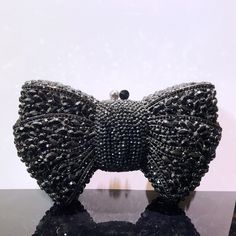 a black beaded bow clutch sitting on top of a table