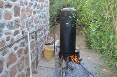 an outdoor fire pit next to a stone wall