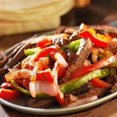 a plate filled with meat and vegetables on top of a wooden table