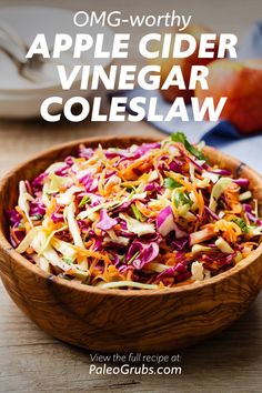 a wooden bowl filled with coleslaw on top of a table