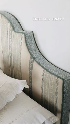 an upholstered headboard on a bed with pillows