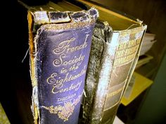 two old books sitting on top of a wooden table