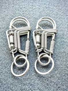 two pairs of metal wire hangers sitting on top of a carpeted floor next to each other