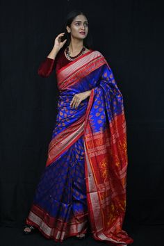 Exclusive hand-woven Sambalpuri silk saree with tribals. Finest pure handwoven sambalpuri ikat silk saree with traditional motifs woven by the master weavers of Sambalpur, Odisha. It has lovely patterns and is world-famous for its stunning colours, texture and designs. Occasion: Party Wear Fabric: Sambalpuri Primary Color: Blue Secondary Color: Red Material: Mulberry Silk/ Sambalpuri Silk Pattern: Motif Border Type: Ikkat Border Size: Medium Blouse Piece: Included Care: Dry Clean Disclaimer : This is a genuine handwoven piece, unevenness in the selvedge and weave could be expected and colours may fade or bleed due to the traditional dyeing method employed. Traditional Banarasi Silk Saree With Ikat Print, Red Tussar Silk Traditional Wear With Ikat Print, Banarasi Silk Saree With Ikat Print For Festivals, Banarasi Silk Dupatta With Ikat Print For Puja, Traditional Wear With Ikat Print In Katan Silk, Diwali Banarasi Silk Traditional Wear With Ikat Print, Traditional Wear In Katan Silk With Ikat Print, Red Ikat Print Traditional Wear For Festivals, Festive Banarasi Silk Traditional Wear With Ikat Print